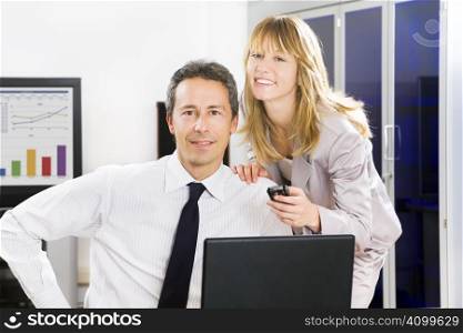 Businesspeople in office looking at camera and smiling