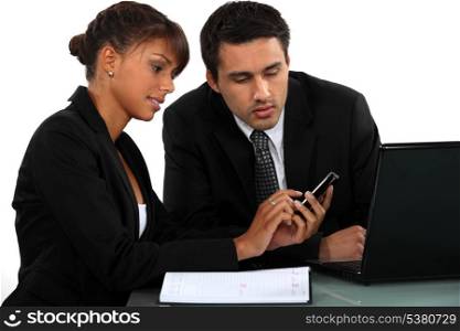 Businesspeople looking at a mobile phone