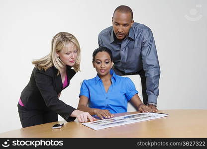 Businesspeople Looking at Booklet in Meeting