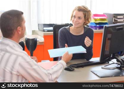 businesspeople sharing documents in a desk at office