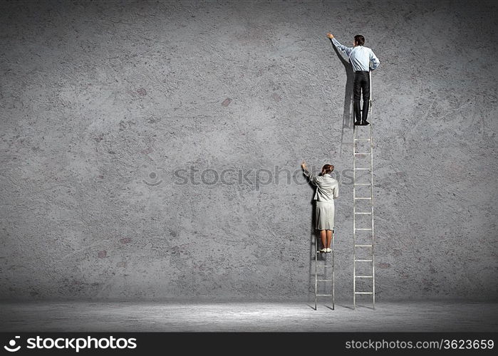 businesspeople standing on ladder drawing diagrams and graphs on wall