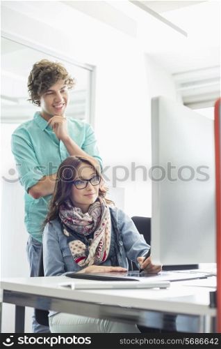Businesspeople using desktop computer in creative office