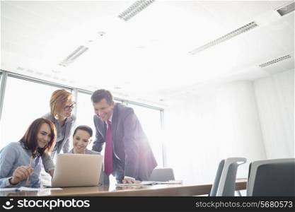 Businesspeople using laptop at conference table