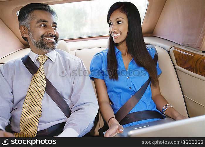 Businesspeople Using Laptop in Car