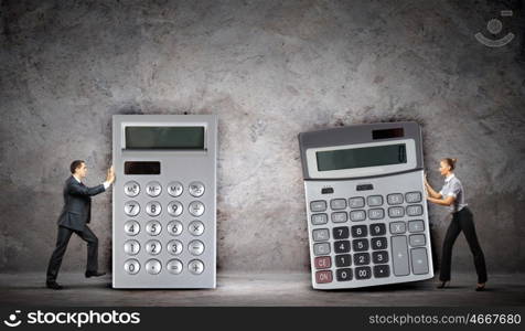 Businesspeople with big calculators. Image of two businesspeople with big calculators
