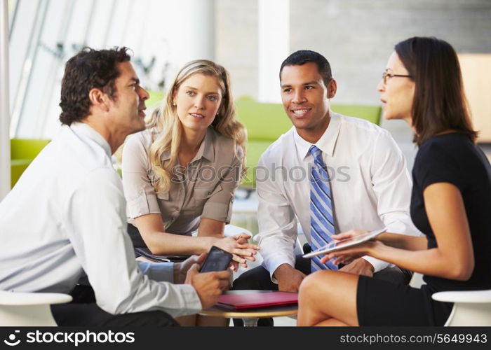 Businesspeople With Digital Tablet Having Meeting In Office