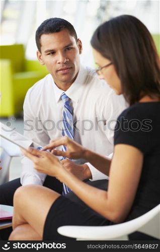 Businesspeople With Digital Tablet Having Meeting InOffice