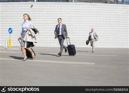 Businesspeople with luggage running on street