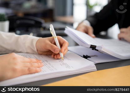 Businesspeople working in the office on official corporate papers, office workers reviewing stack of financial documents and working on business report. Equilibrium. Businesspeople working in the office on official corporate papers. Equilibrium