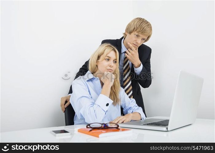 Businesspeople working on laptop in office