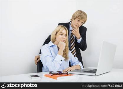 Businesspeople working on laptop in office