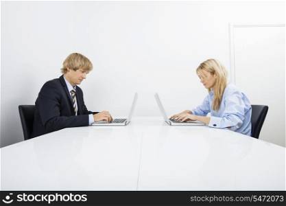 Businesspeople working on laptops in office
