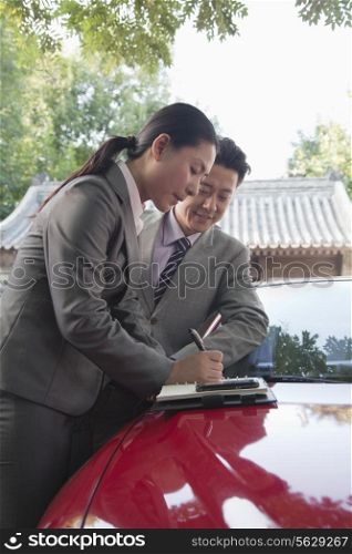 Businesspeople Working Outdoors on the Hood of a Car