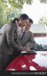 Businesspeople Working Outdoors on the Hood of a Car