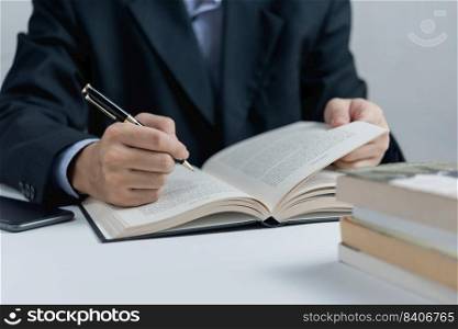 Businessperson reading and writing on book.education studying knowledge development and cognition learning concept.