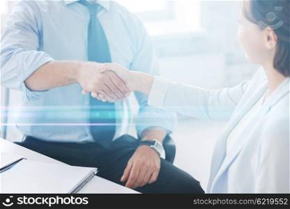 businesss and office concept - businessman and businesswoman shaking hands in office. business people shaking hands in office