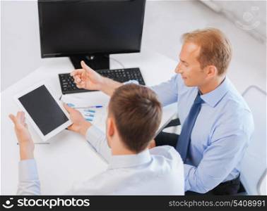 businesss and office concept - businessmen with notebook and tablet pc discussing graphs on meeting