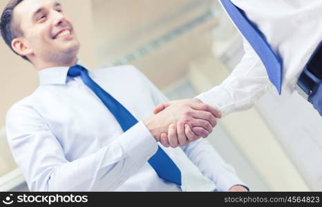 businesss and office concept - two businessmen shaking hands in office. two businessmen shaking hands in office