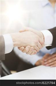 businesss and office concept - two businessmen shaking hands in office. two businessmen shaking hands in office