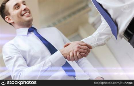 businesss and office concept - two businessmen shaking hands in office. two businessmen shaking hands in office