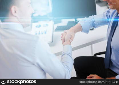 businesss and office concept - two businessmen shaking hands in office. businessmen shaking hands in office