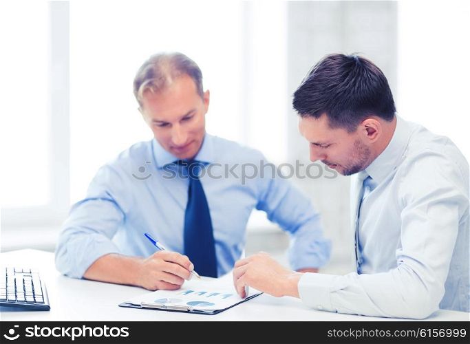 businesss concept - two businessmen discussing graphs on meeting. businessmen with notebook on meeting