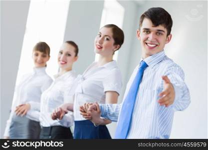 Businessteam holding hands. Image of four businesspeople standing in row. Partnership concept