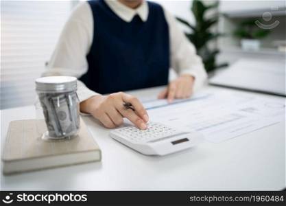 Businesswoman Accountant analyzing investment charts Invoice and pressing calculator buttons over documents. Accounting Bookkeeper ClerkBank Advisor And Auditor Concept.