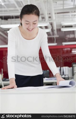 Businesswoman analyzing architecture project in the office