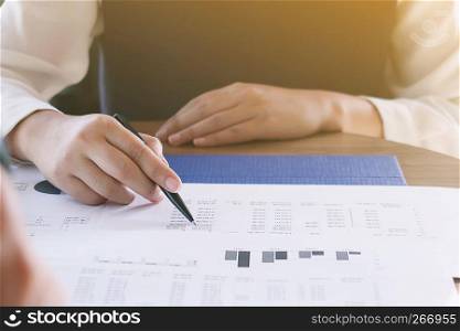 Businesswoman analyzing investment charts and pressing calculator buttons over documents. Accounting Concept