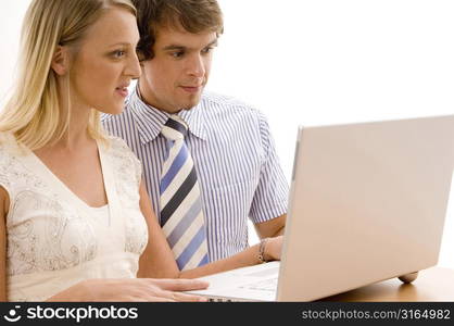 Businesswoman and a businessman looking at a laptop