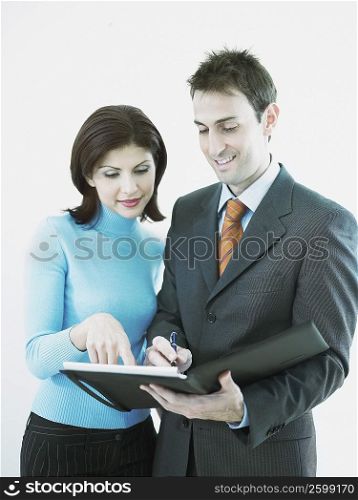 Businesswoman and a businessman looking at a personal organizer