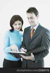 Businesswoman and a businessman looking at a personal organizer