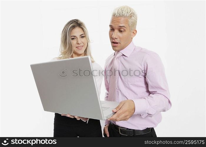 Businesswoman and a businessman using a laptop