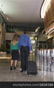 Businesswoman and a businessman walking at an airport