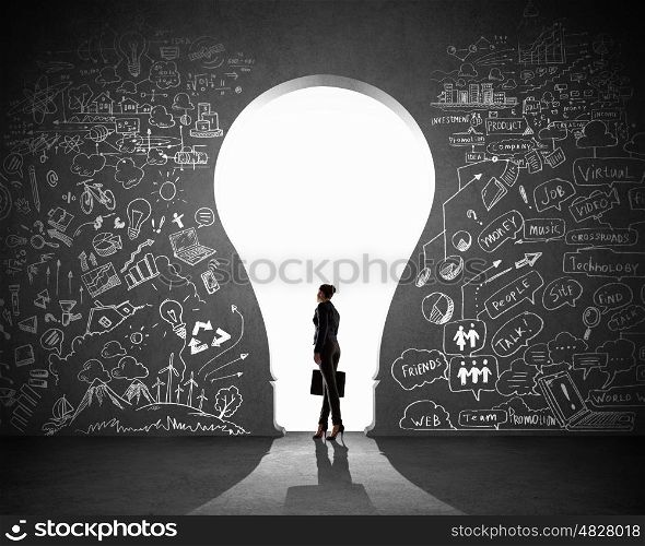Businesswoman and business plan. Silhouette of businesswoman against black wall with key hole