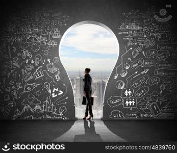 Businesswoman and business plan. Silhouette of businesswoman against black wall with key hole