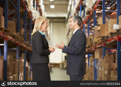 Businesswoman And Businessman In Distribution Warehouse