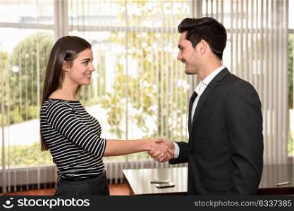 businesswoman and businessman shaking hands, finishing up a meeting