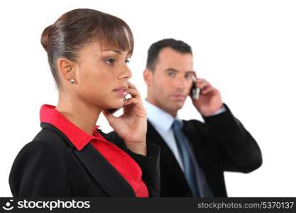 businesswoman and businessman talking on their cells