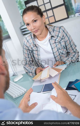 businesswoman and colleague discussing over blueprint in the office