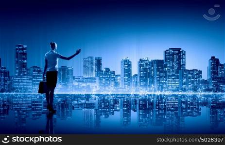 Businesswoman and night city. Businesswoman standing with back against night city panoramic view