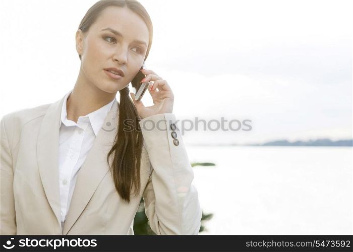 Businesswoman answering cell phone outdoors
