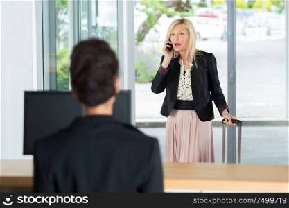 businesswoman arrive to hotel check in talking on the phone