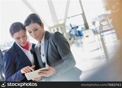 Businesswoman asking for assistance with passenger service agent in airport