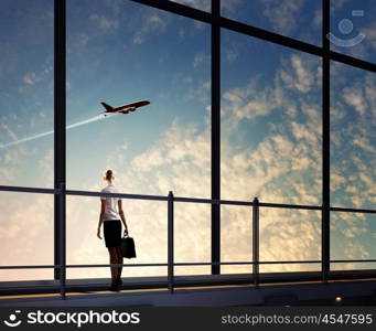 Businesswoman at airport. Image of businesswoman at airport looking at airplane taking off