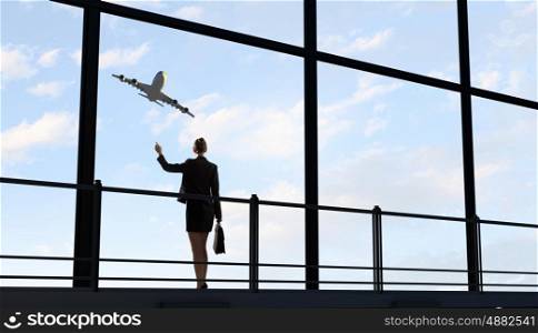 Businesswoman at airport. Image of businesswoman at airport looking at airplane taking off