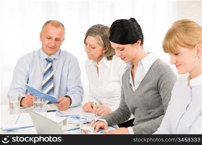 Businesswoman at team meeting with colleagues discussing performance reports