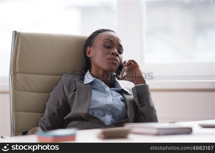 Businesswoman at workplace sitting relaxed and calling by phone
