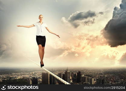 Businesswoman balancing on rope